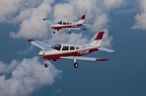 Two small planes flying in the sky